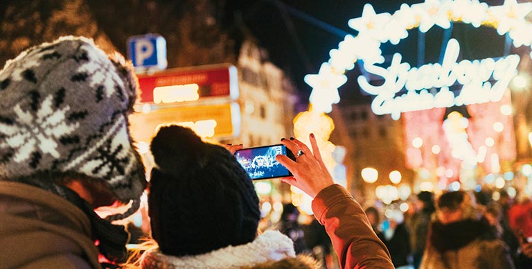 A couple taking photos at the Marché de Noël in Strasbourg